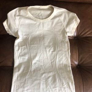 Lulu lemon tee. Off white. Hard to tell but there’s some flower details
